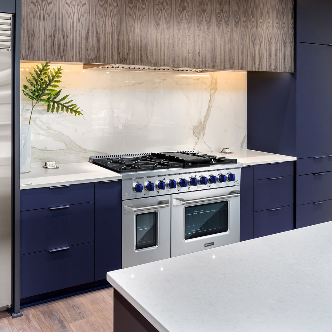 Mueller 48 inch gas range with blue knobs in a blue kitchen with white marble backsplash