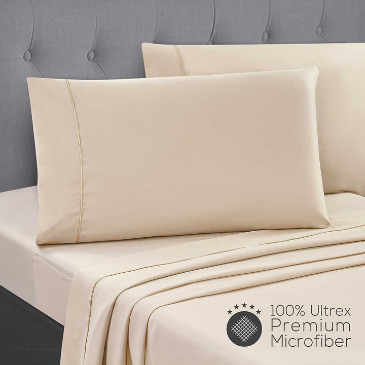 Beige bed sheets and pillow on a bed with a gray headboard, featuring 100% Ultrex Premium Microfiber label.