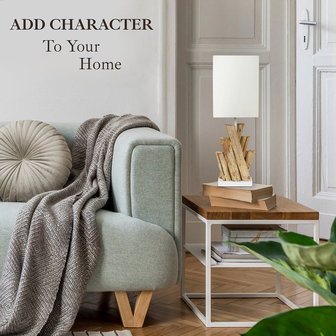 Cozy living room with a gray armchair, wooden side table, and decorative lamp.
