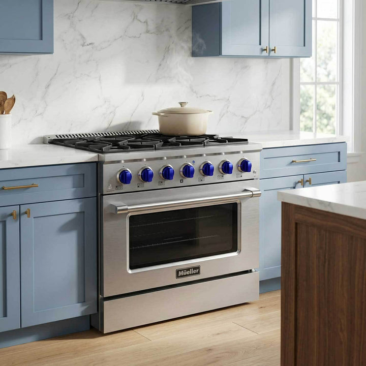 Mueller branded 36 inch stainless steel gas range, with blue knobs, blue kitchen cabinets left and right of the gas range and a beige Dutch oven on the gas cooktop.