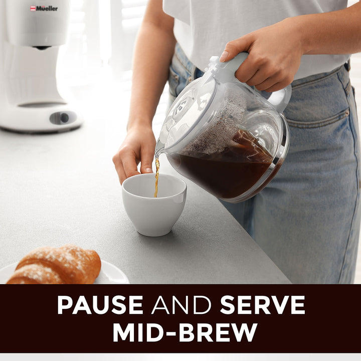 Person pouring coffee from a glass carafe into a white cup on a kitchen counter emphasis on the pause and swerve mid-brew option.