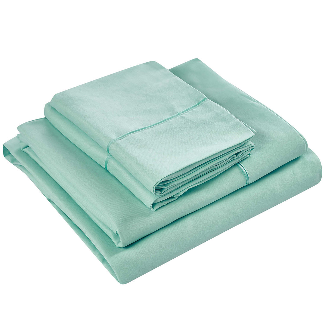 Set of light green bed sheets and pillowcases on a white background