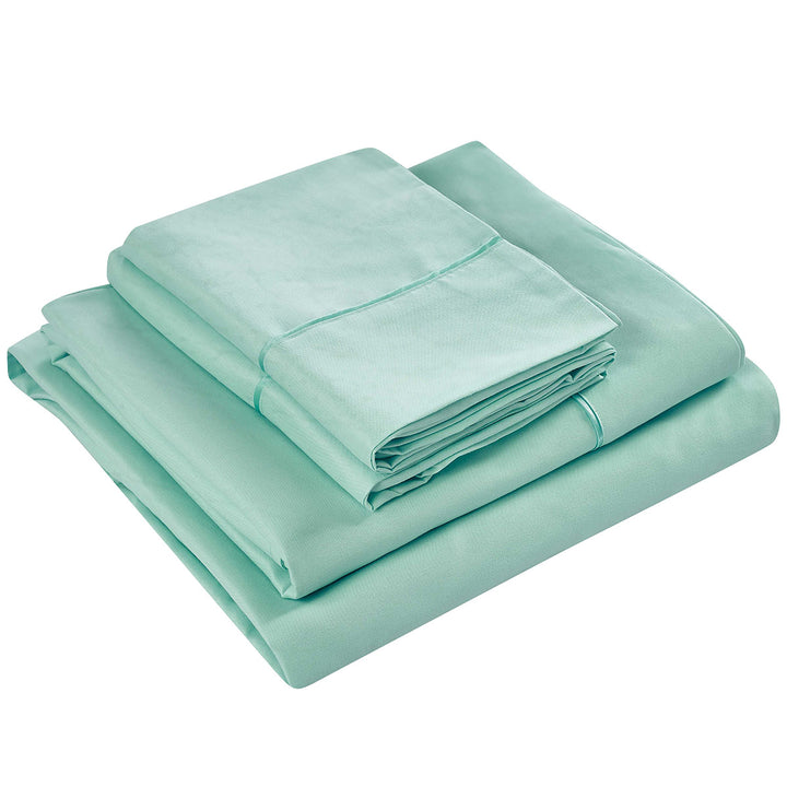 Set of light green bed sheets and pillowcases on a white background