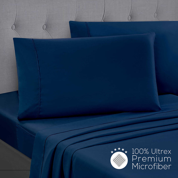 Blue bed sheets and pillowcases on a bed with a gray headboard, featuring 100% Ultrex Premium Microfiber label.