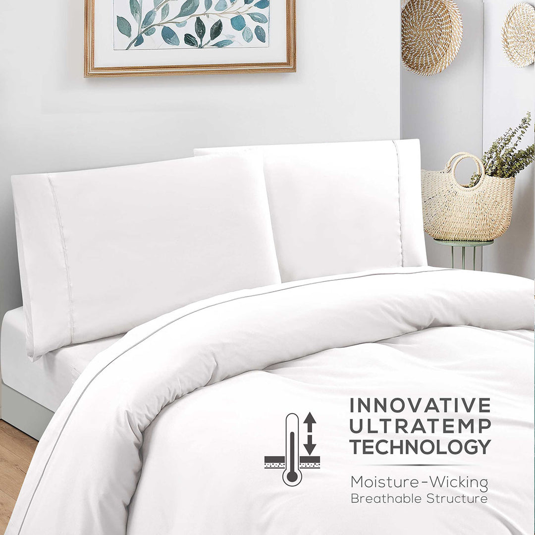 White bedding set with 'Innovative Ultratemper Technology' label on a bed in a bedroom setting.