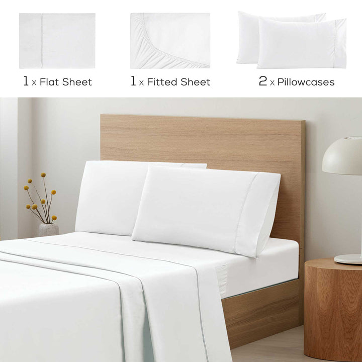 White bed sheets and pillowcases set on a bed with wooden headboard and nightstand.