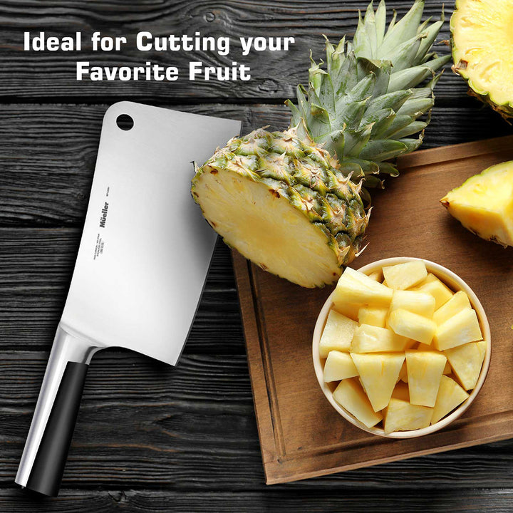 Mueller Cleaver Knife stainless steel next to a whole pineapple, chopped pineapple in a bowl, and text 'Ideal for Cutting your Favorite Fruit' on a wooden surface.