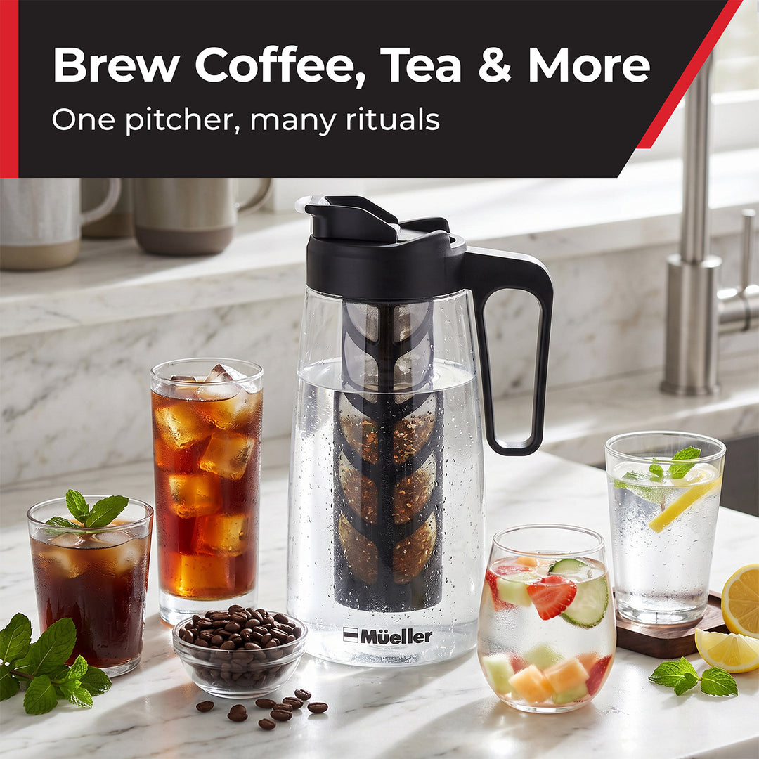 A clear Mueller glass coffee/tea infuser pitcher with a black handle and lid sits on a marble countertop, surrounded by glasses of iced coffee, tea, and fruit water, with coffee beans in a small bowl. 