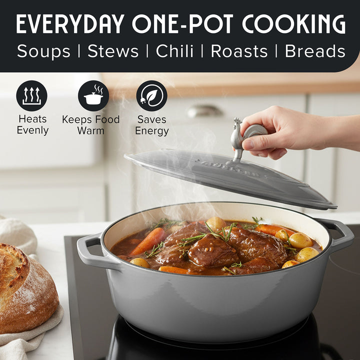 Mueller Enameled Gray Dutch Oven Oval shaped setup with a pot of stew, bread, and a hand holding a lid in a kitchen.
