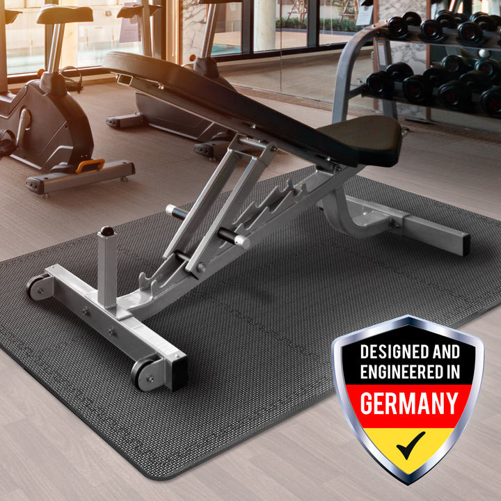 Gym equipment on a gray mat with a 'Designed and Engineered in Germany' badge.