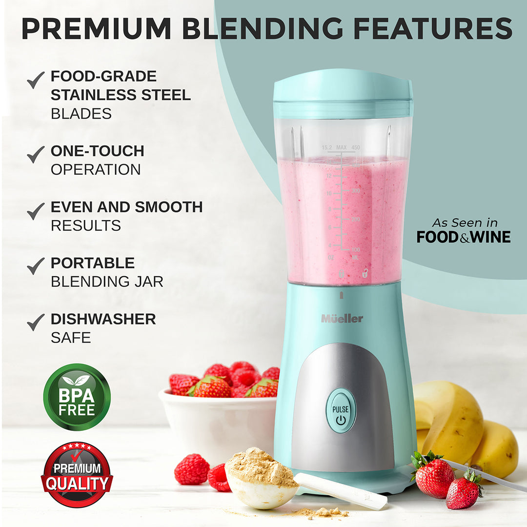 Portable blender with pink smoothie, surrounded by fruits and ingredients, on a light background.