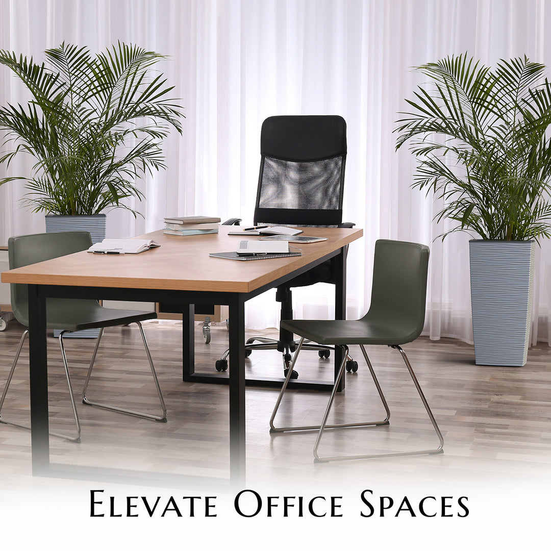 Modern office setup with a table, chairs, and plants potted in Mueller Planters in a bright room.