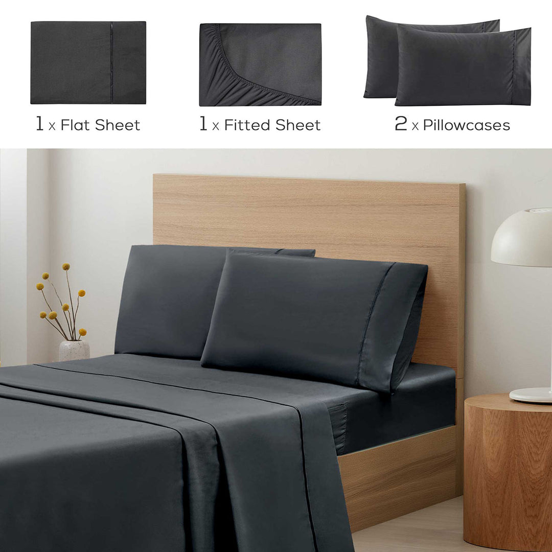 Set of dark gray bedding with flat sheet, fitted sheet, and pillowcases displayed on a bed.